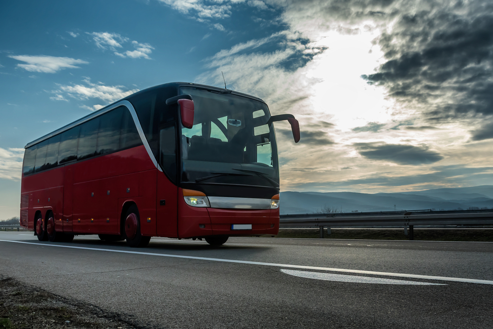 Czerwony, ekskluzywny autobus jadący przez autostradę - e-tollgps.pl